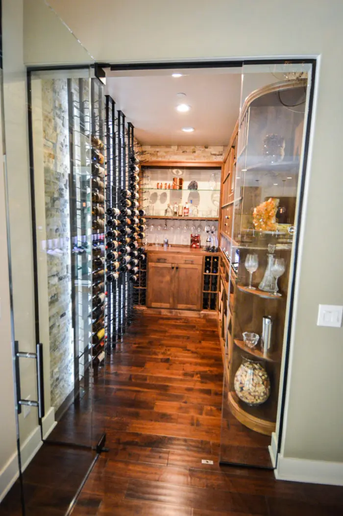 This design uses traditional wood, modern metal, and glass to transform this office space into a beautiful, transitional wine room.
