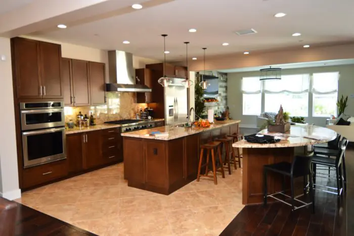 Here we can see the wood cabinets, flooring, and wall. The sleek, modern appliances and granite countertops add a contemporary element to the more traditional wood. We took the same approach with the custom wine cellar--we combined metal and wood to bring together the Transitional Designs.