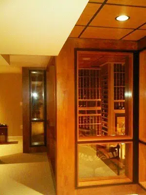 The Glass Door and Walls Add a Modern Appeal to this Custom Home Wine Cellar 