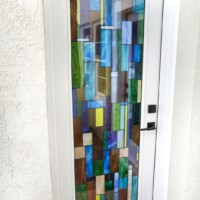 This Barolo-style door features custom stained glass, and is a dramatic entrance to this residential wine cellar.