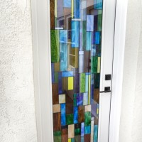 This Barolo-style door features custom stained glass, and is a dramatic entrance to this residential wine cellar.