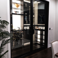 This custom glass wine cellar has enough space for someone to comfortably walk around and look for his/her wine of choice.