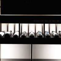 We also built a light valance through the entire reveal row of this custom glass wine cellar. The light valance hides our LED light strips, so it gives that slightly dramatic effect.