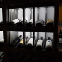 All reveal rows in this wooden wine racking is lined with a light valance. A light valance is used to hide light strips or bulbs so people can only see the light that it produces.