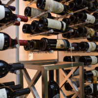 This glass wine cellar's metal wine racks are composed of pegs that could hold 3 bottles a pair. Since installation is literally anchoring every single peg manually to the wall, you can customize the arrangement in anyway you want.