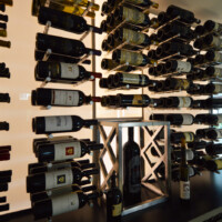 This glass wine room has both ceiling lights and wall lights. The wall lights is an entire LED panel that's installed behind acrylic boards. All the wine peg racks are built through our wall lighting panel.