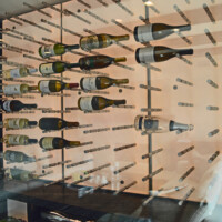 The metal wine pegs in this modern wine room were screwed into the acrylic light boards. Modern Wine Room Metal Wine Racks and Acrylic LED Lights