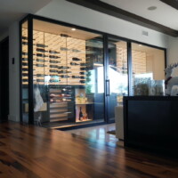 Even in broad daylight, this modern wine room pops out because of its theatrical lighting. Living Room Modern Wine Rooms