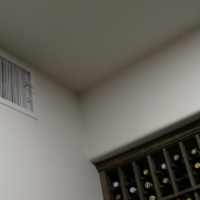 The air supply comes from this ducted vent and circulates through the custom wine racks. Custom Wine Cellar Cooling Above Racking