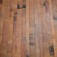 Repurposed wine barrel staves were used for the flooring in order to match the rustic-themed custom wine racks. Custom Wine Racks Repurposed Barrels