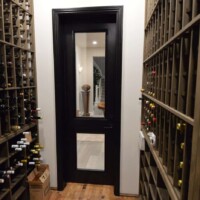 Although rustic, custom wooden wine racks still look great inside semi-modern wine cellars with glass paneling. Custom Wine Racks in Semi Modern Wine Cellar