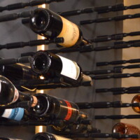 Triple-deep wine cellar pegs in satin black holds part of the owner's wine collection. Using this kind of storage approach was a great way to maximize the room's storage potential. Black Home Wine Cellar Peg Wine Racks