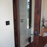 A tempered glass door and two glass windows on the side gives visitors a glimpse into this unique home wine room. Home Wine Room Single Barolo Door