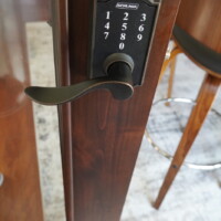 A contemporary style door lock is used to secure this home wine room's collection. Passcode-Locked Home Wine Room