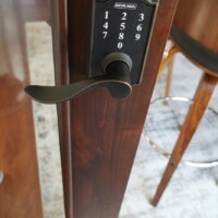 A contemporary style door lock is used to secure this home wine room's collection. Passcode-Locked Home Wine Room