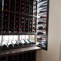This is the display window seen from the living room. It's easy to grab and change the bottles even if that portion is partially blocked by the large wooden wine rack. Refrigerated Custom Wine Cellar Display Window