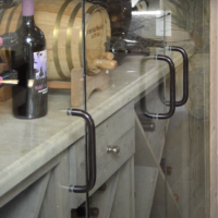 Stainless steel handles help open this small wine cellar's glass doors. The glass panels are single paned and are lined by rubber strips for added seal around the edges. Small Glass Wine Cellar Single Paned Door