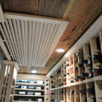 The register of this home wine room's split-system was concealed behind a wooden grill so it still matches the rustic aesthetic of the wine cellar. Ceiling Mounted Split System for Home Wine Rooms