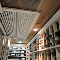 The register of this home wine room's split-system was concealed behind a wooden grill so it still matches the rustic aesthetic of the wine cellar. Ceiling Mounted Split System for Home Wine Rooms